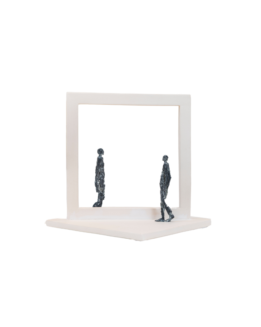 Abstract sculpture of two figures inside a square frame on a white background