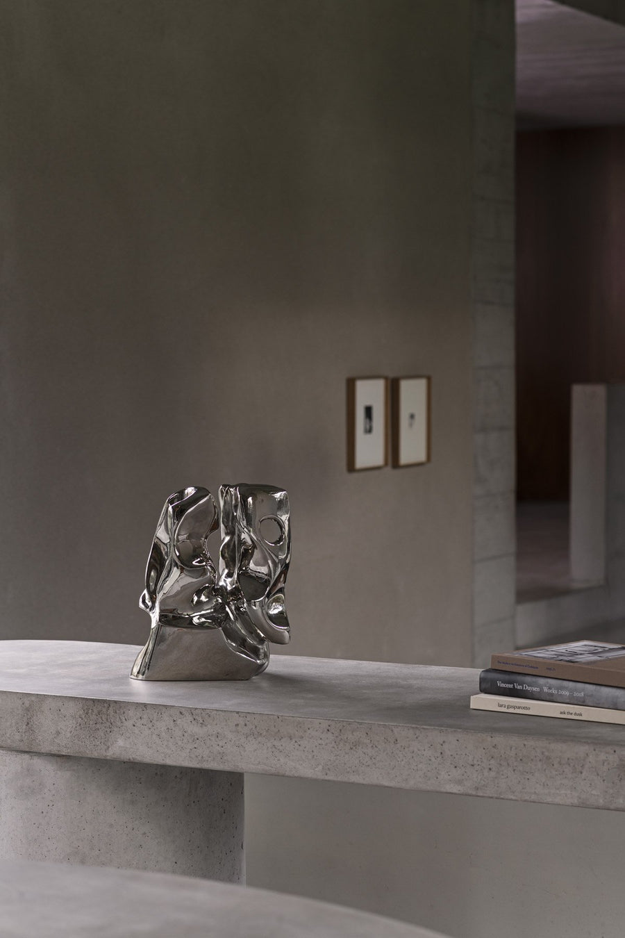 Metallic sculpture on a concrete surface with a neutral background