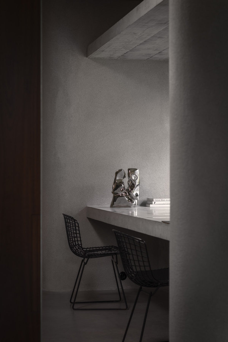 Modern interior with a desk and chairs in a minimalistic setting and the Shifting Perspectives limited edition bronze sculpture from Gardeco