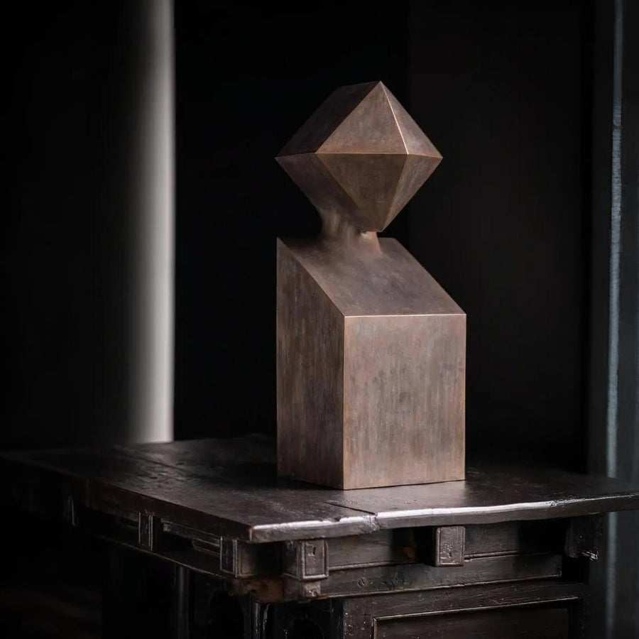 Abstract metallic sculpture on a dark surface with a black background
