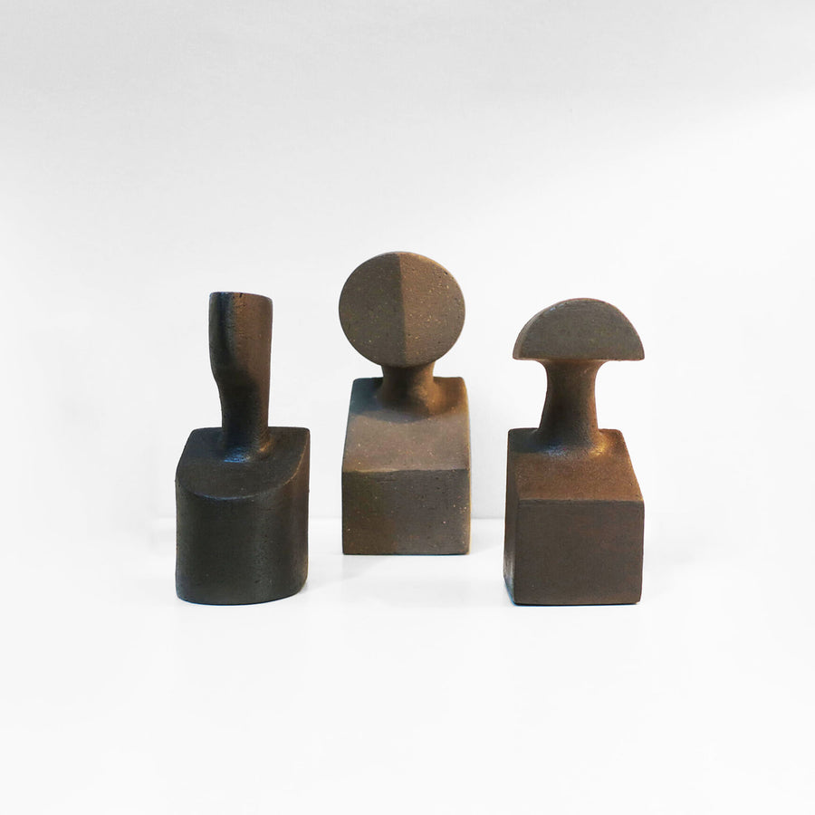 A group of Gardeco Ceramic Sculpture The Muses Plus Urania Natural sculptures, featuring black and brown objects.