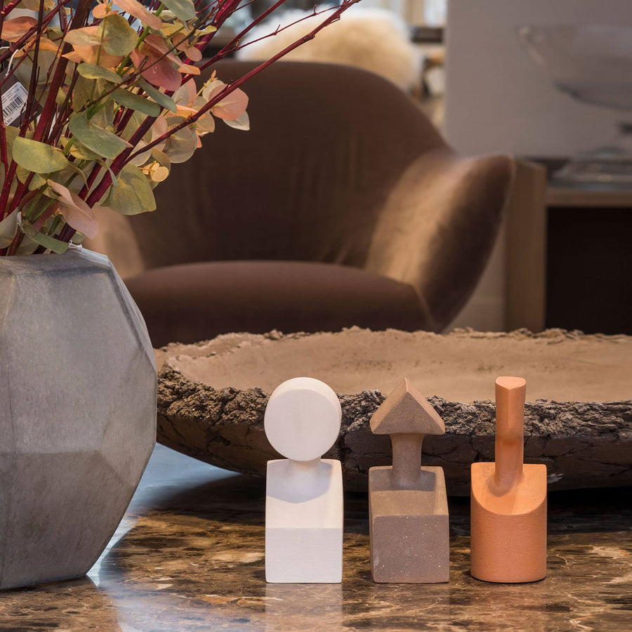 A living room adorned with a stunning Gardeco Ceramic Sculpture The Muses Plus Urania Ochre, complemented by an elegant vase of flowers and a select few pieces of furniture.