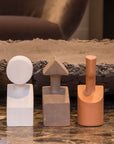 Three Gardeco Ceramic Sculpture The Muses Plus Urania Ochre sculptures sitting on a marble table with an ochre finish.