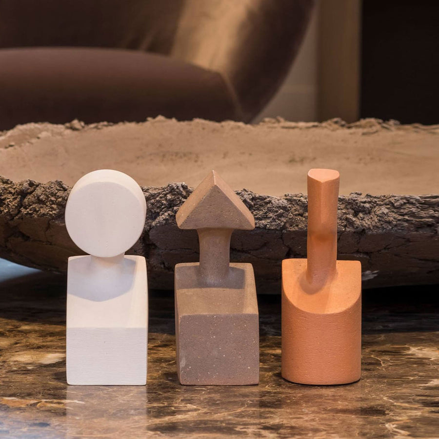 Three Gardeco Ceramic Sculpture The Muses Plus Urania Ochre sculptures sitting on a marble table with an ochre finish.