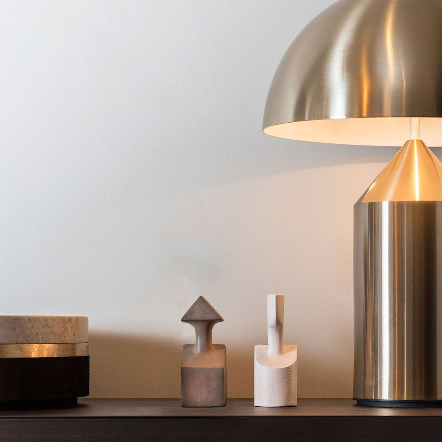 A Gardeco Ceramic Sculpture The Muses Small Calliope Natural table lamp is sitting on top of a wooden shelf.