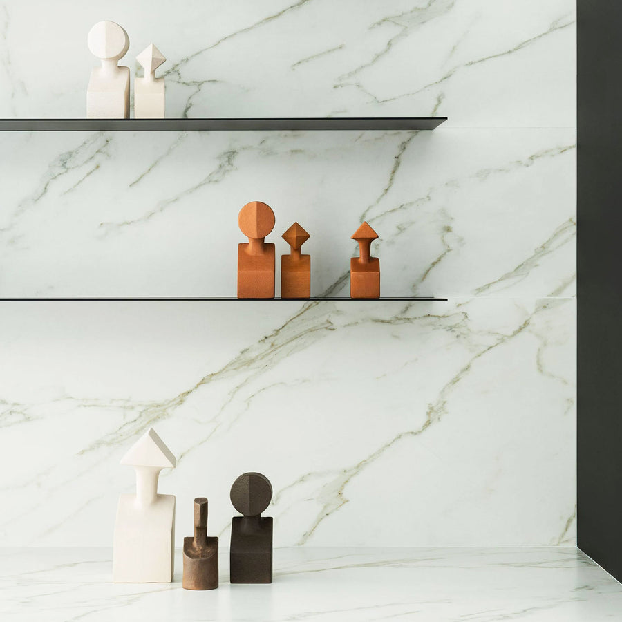 A white marble shelf with Gardeco Ceramic Sculpture The Muses Small Calliope Ochre figurines representing Muses from Greek mythology.