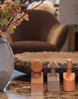 A vase of flowers sits on a table in a living room, accompanied by the Gardeco Ceramic Sculpture The Muses Small Clio Ochre.