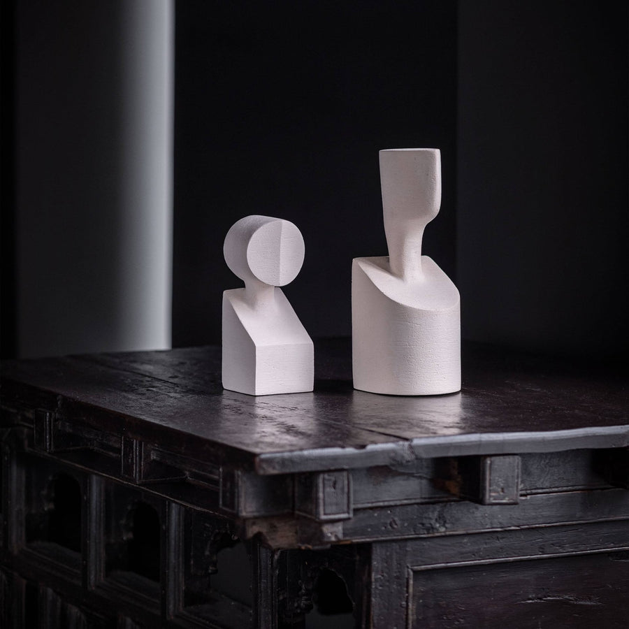 Two Gardeco Ceramic Sculpture The Muses Small Clio White vases sit on a table in a dark room.