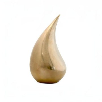 Gold teardrop-shaped decorative object on a white background from Gardeco at Spacio store in Mumbai