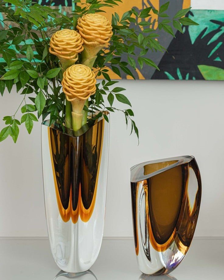 An exquisite vase with elegant flowers and a Gardeco Glass Vase Triangle 4 Fume Amber on a table.