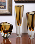 An elegant display of Gardeco Glass Vase Triangle 4 Fume Amber on a table.