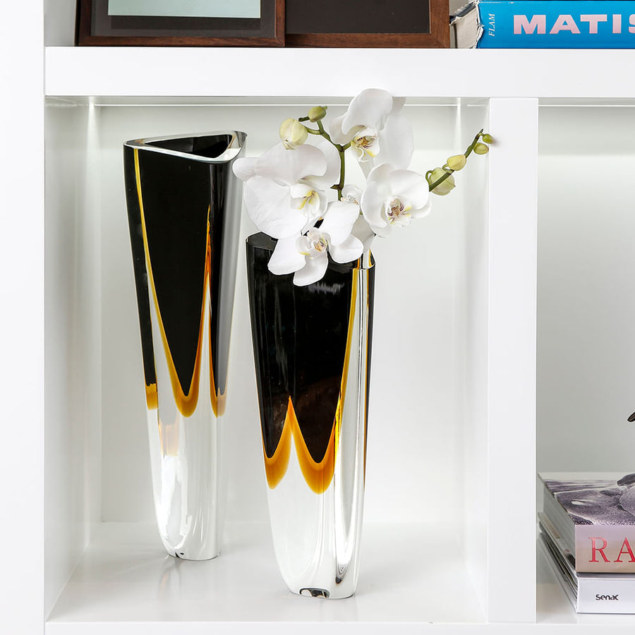 A Gardeco Glass Vase Triangle 1 Black Amber with bicolour glass and beautiful flowers in it.