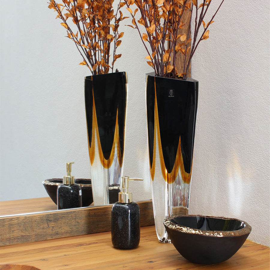 A contemporary refinement of the Gardeco Glass Vase Triangle 1 Black Amber with dried flowers, featuring bicolour glass.