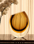 A Gardeco Glass Vase 96 Fume Amber on a table.