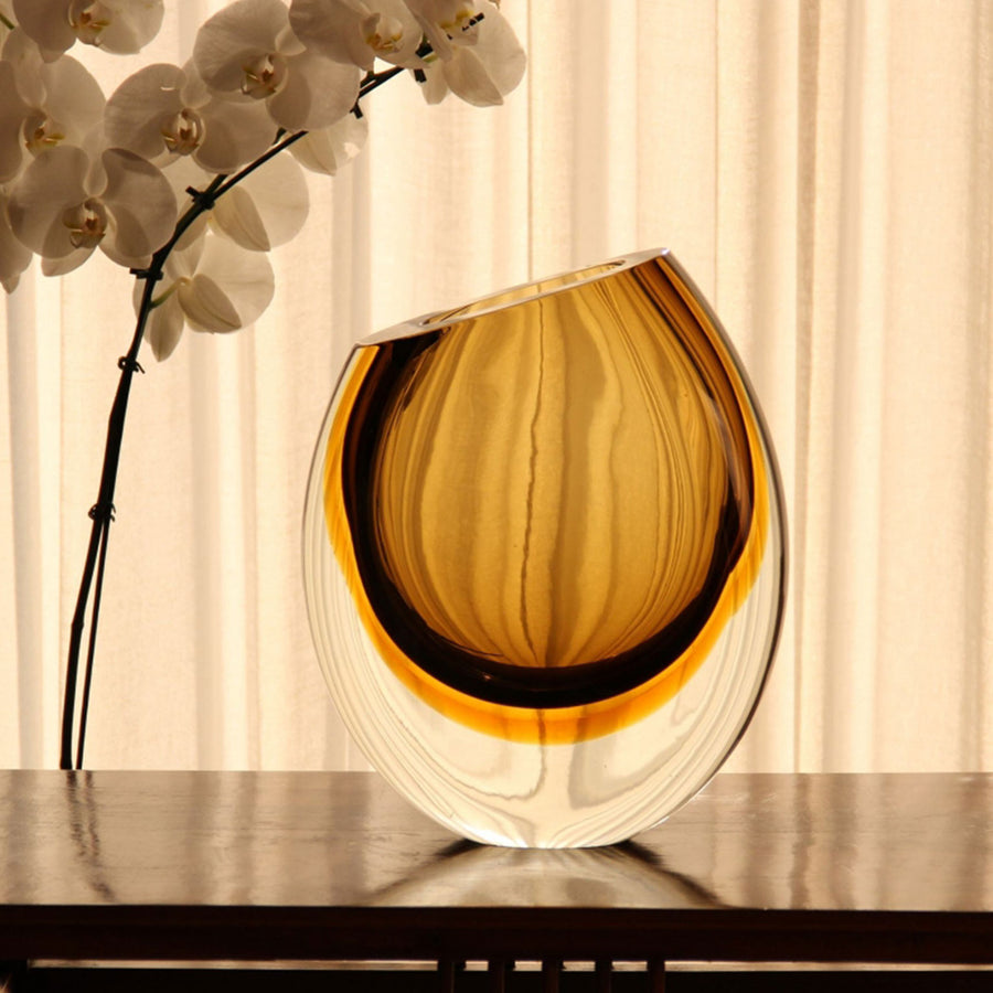 A Gardeco Glass Vase 96 Fume Amber on a table.