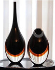 A versatile design of a Gardeco Glass Vase Drop Large Black Amber placed on a sleek black surface.