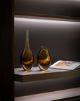 A pair of Gardeco Glass Vase Drop Large Fume Amber, displayed on a shelf.