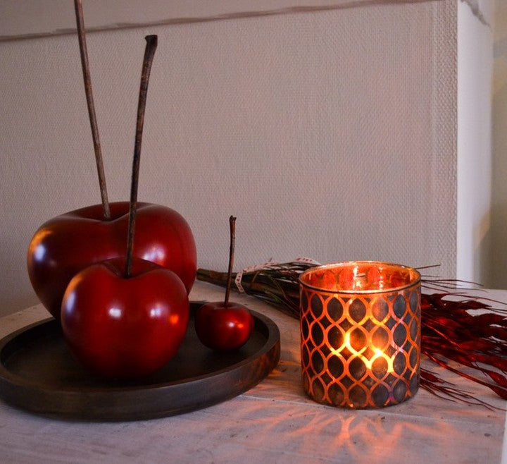 A Gardeco ceramic sculpture of red apples sits on a table.