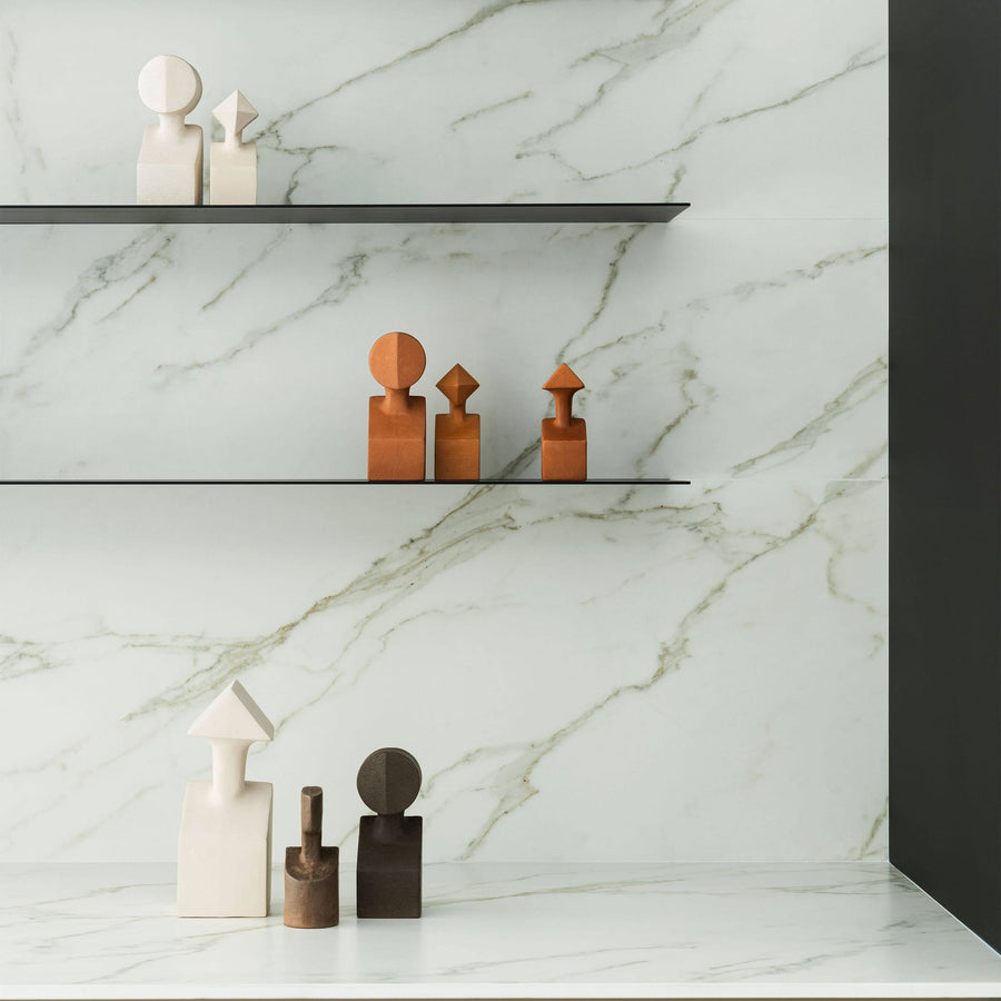 A white marble shelf with Gardeco Ceramic Sculpture The Muses Plus Calliope Ochre figurines on it.