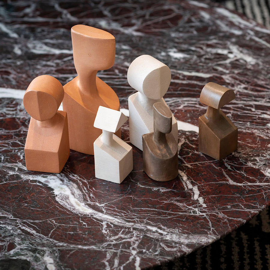 A group of Gardeco Ceramic Sculpture The Muses Plus Clio Ochre figurines, arranged on a marble table.