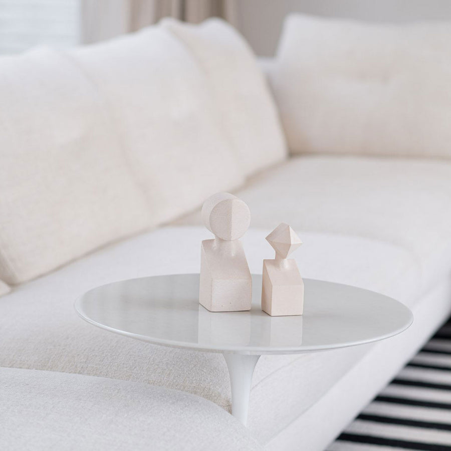 A Gardeco Ceramic Sculpture The Muses Plus Clio White couch with a white table in front of it, featuring a sleek white finish.