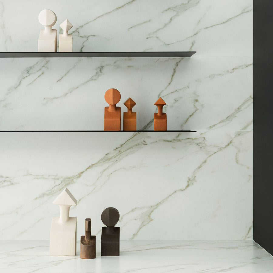 A white marble shelf with Gardeco Ceramic Sculpture The Muses Plus Clio White figurines on it, featuring a beautiful white finish.