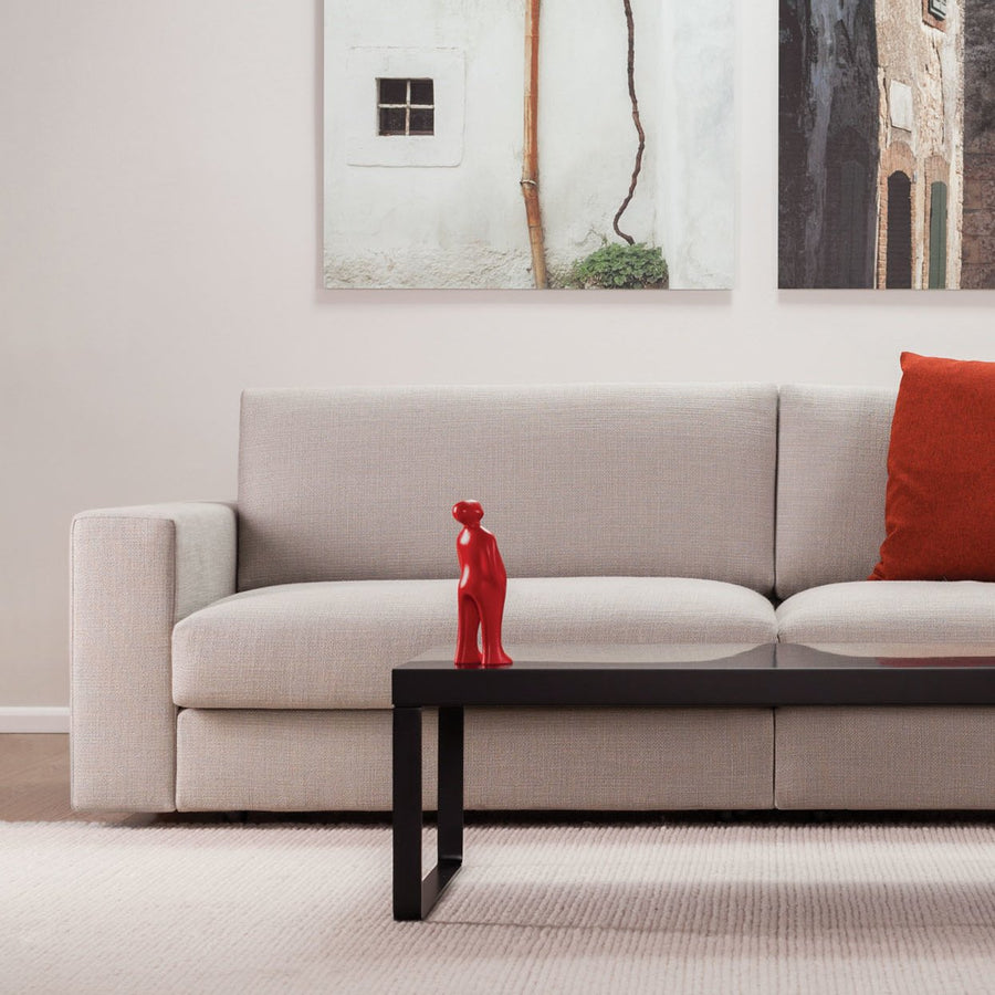 A gray couch in a living room, adorned with a Gardeco Ceramic Sculpture Visitor Small Red Urucum titled "The Visitor".