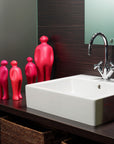 A bathroom with a sink and a mirror featuring The Visitor, a Gardeco Ceramic Sculpture Visitor Small Red Urucum.