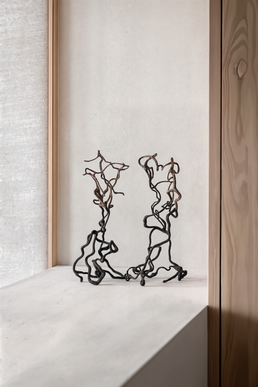 Pair of Gardeco To Return limited edition bronze sculptures styled on a ledge, luxury home art pieces available at Spacio India retail stores.