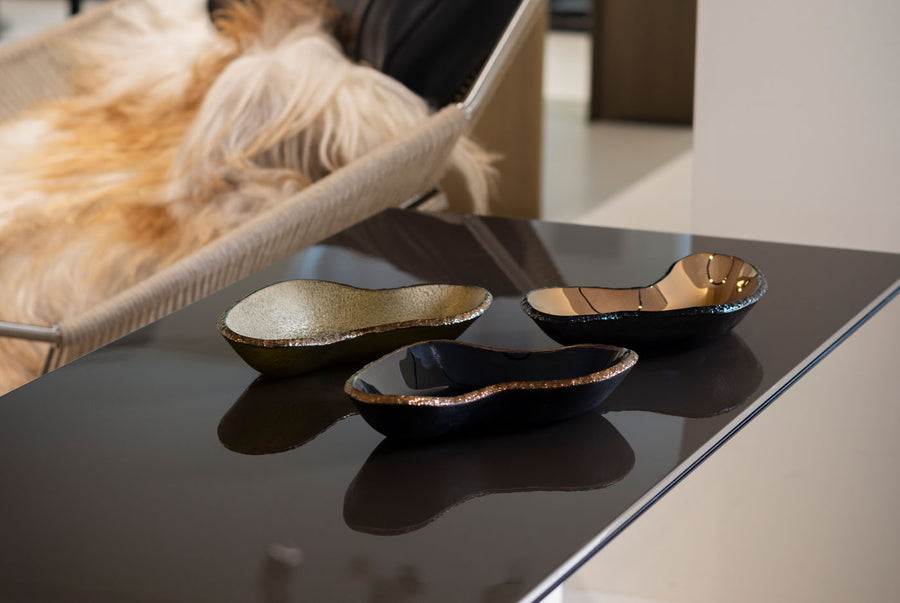 Collection of Gardeco AME Ameba Platters in luxury finishes, displayed on a glossy black table – available at Spacio India