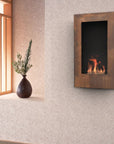 A wall-mounted rectangular fireplace with a dark insert and glowing flames, set into a textured beige wall beside a window with a vase of greenery on the sill.
