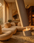 Modern living room with beige sofa, fire pit, and large windows.