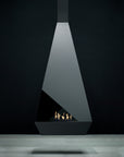 Modern freestanding fireplace with a dark glass front against a black background