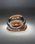 Glass object on a gradient gray background from Glasremis of Lithuania available at Spacio retail store in Mumbai. 
