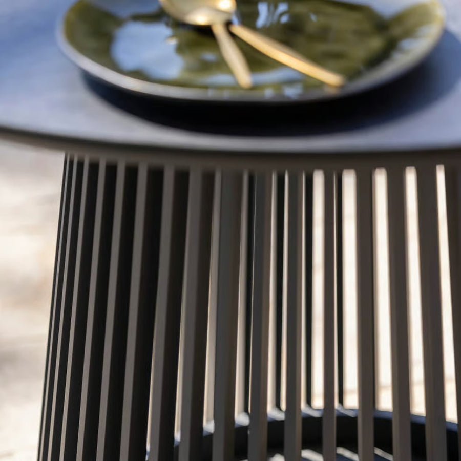 Close-up of a black high table with a blurred plate in the background