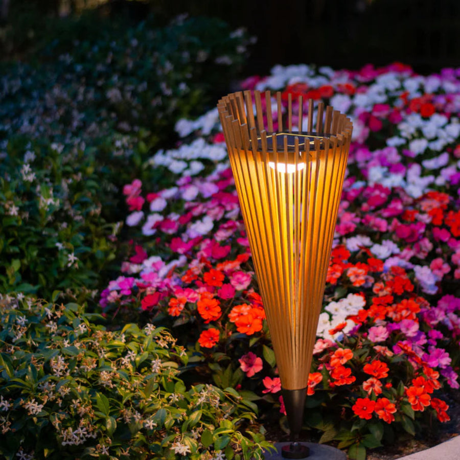 Decorative garden solar torch with flowers in the background by Les Jardins available at Spacio retail stores in Mumbai & Kolkata.  