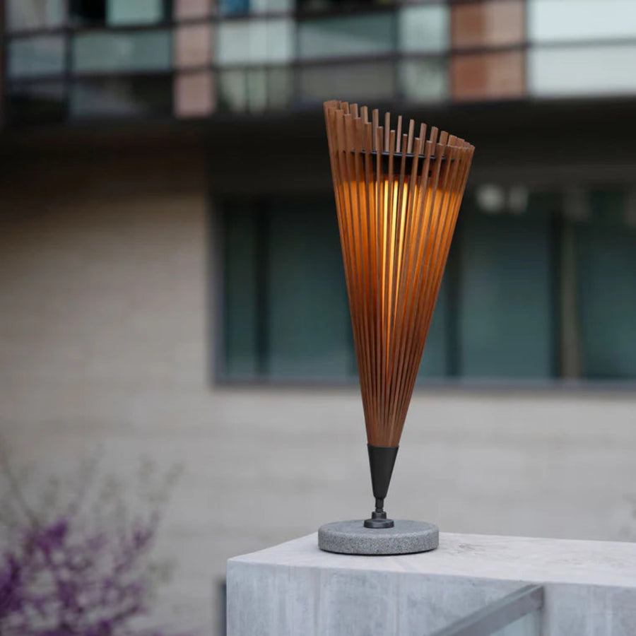 Tall, cone-shaped solar lamp with wooden slats on a stone pedestal outdoors by Les Jardins available at Spacio retail stores in Mumbai & Kolkata.  