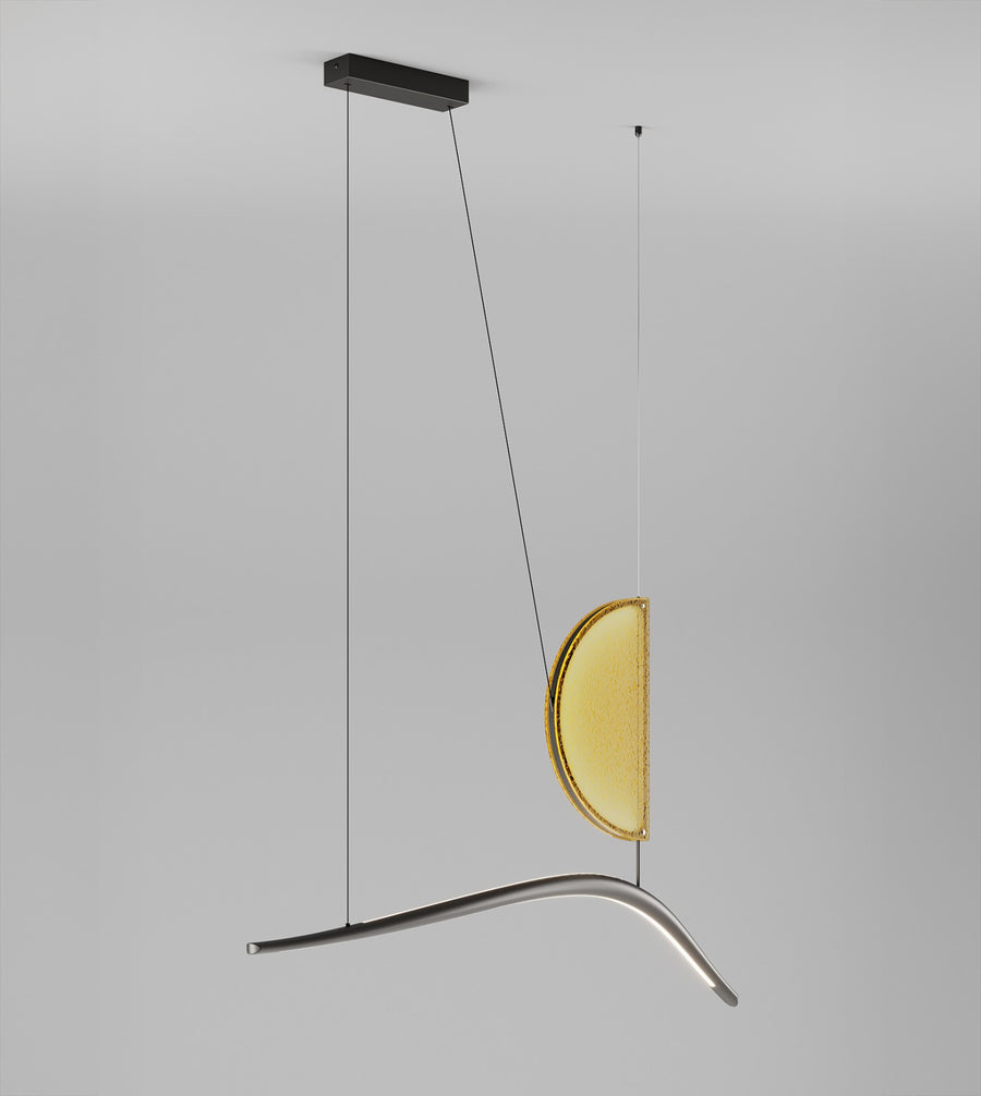 Modern pendant light with a yellow glass shade on a gray background