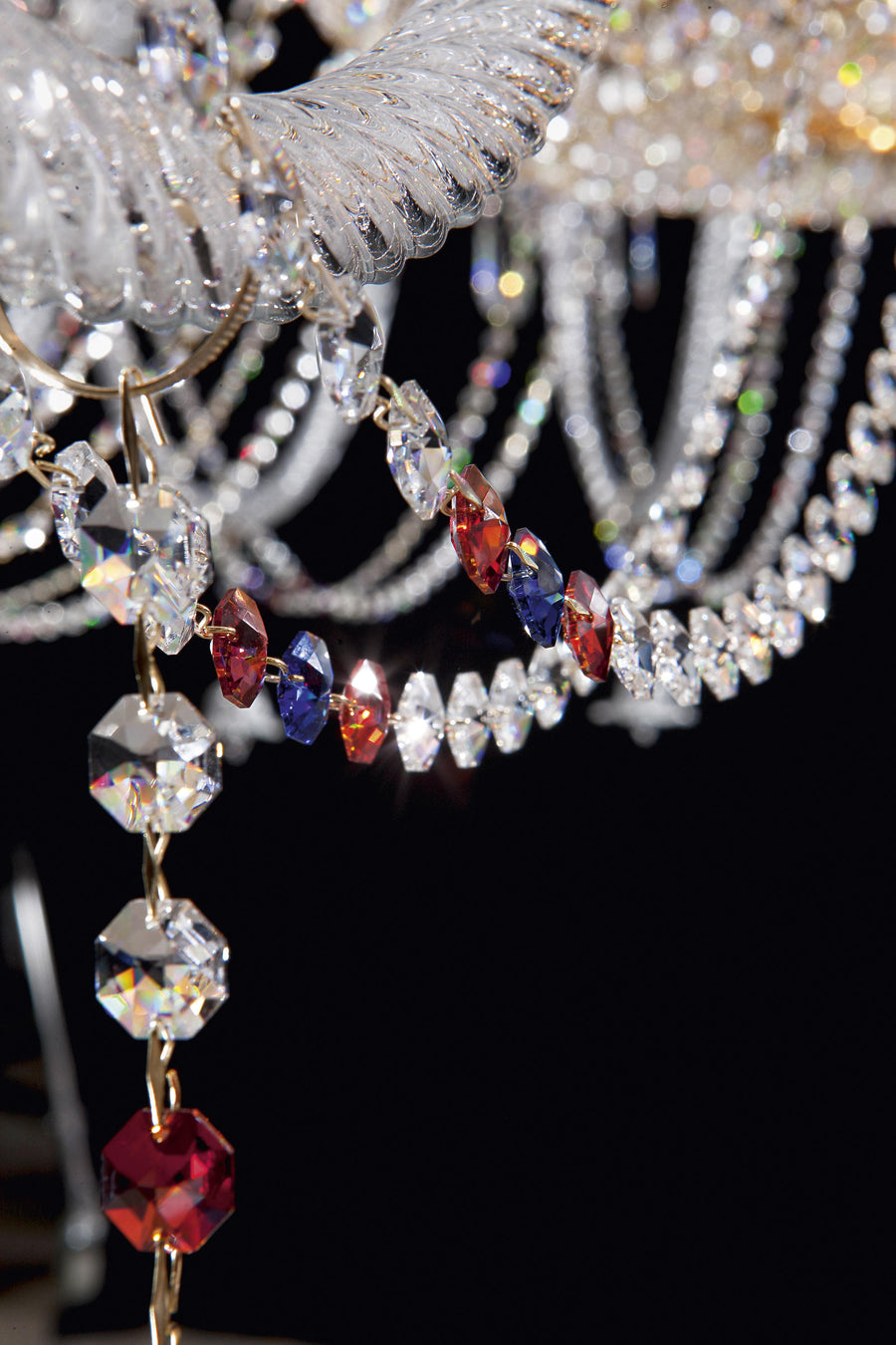 Close-up of Italamp Dogma chandelier arm detail with red, blue, and clear crystal pendants, highlighting luxury lighting by Italamp at Spacio India.
