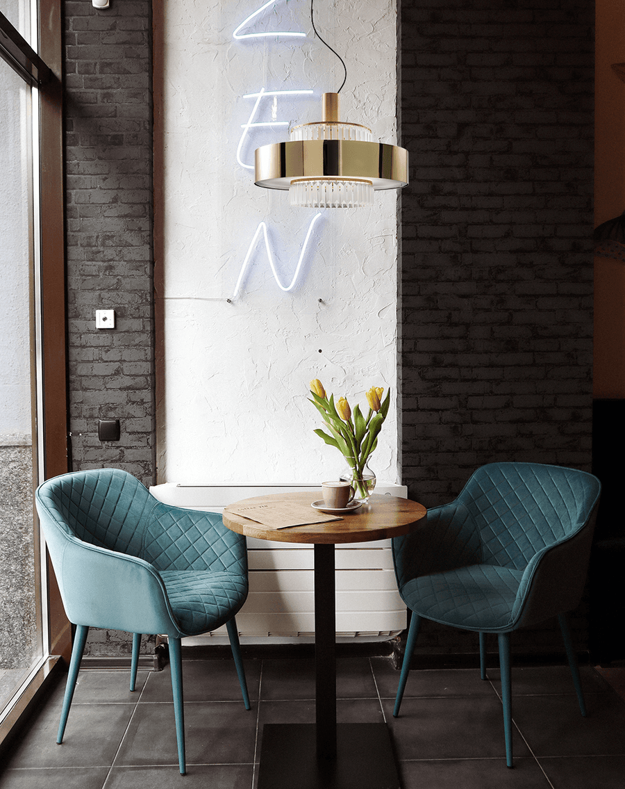 Elegant Italamp Crono Suspension Lamp with layered gold rings and glass pendants, styled in a contemporary café setting, available at Spacio India.