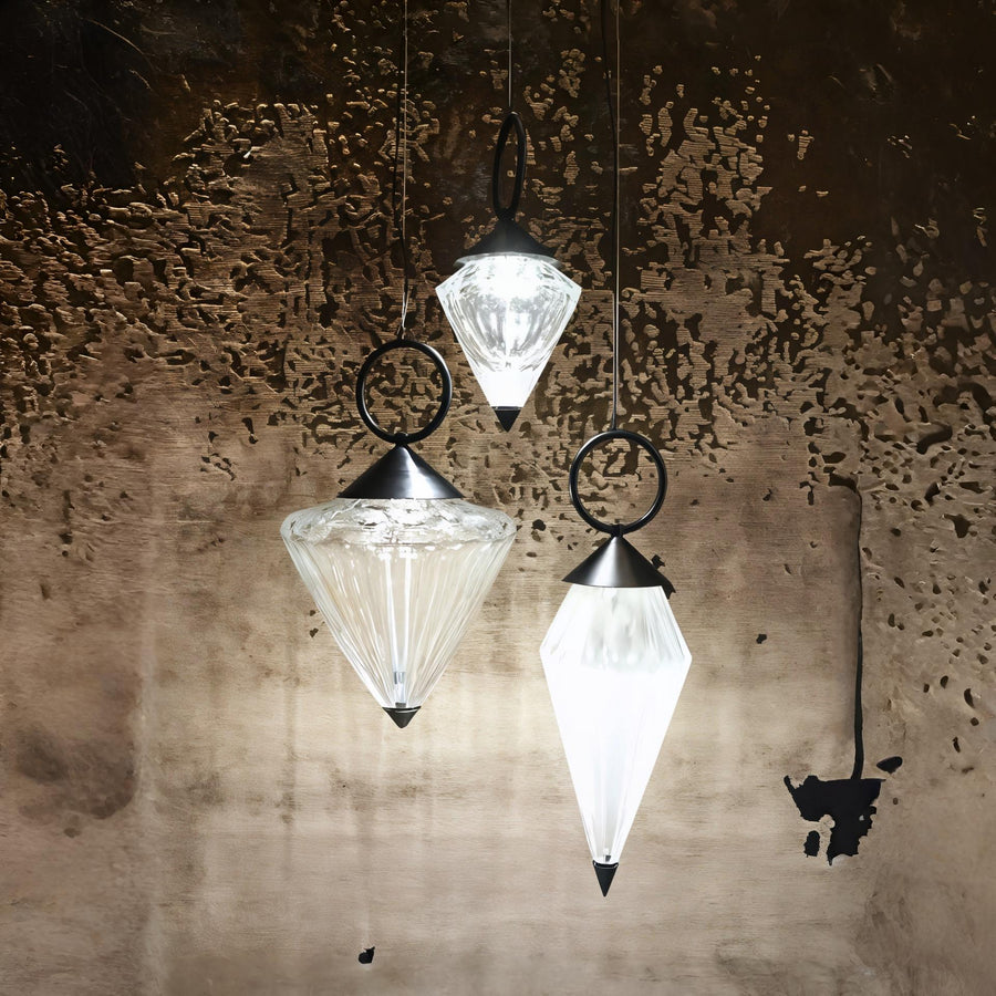 Warmly lit Italamp Donna Suspension Lamp with black accents, creating a dramatic glow against a textured wall – premium lighting at Spacio India