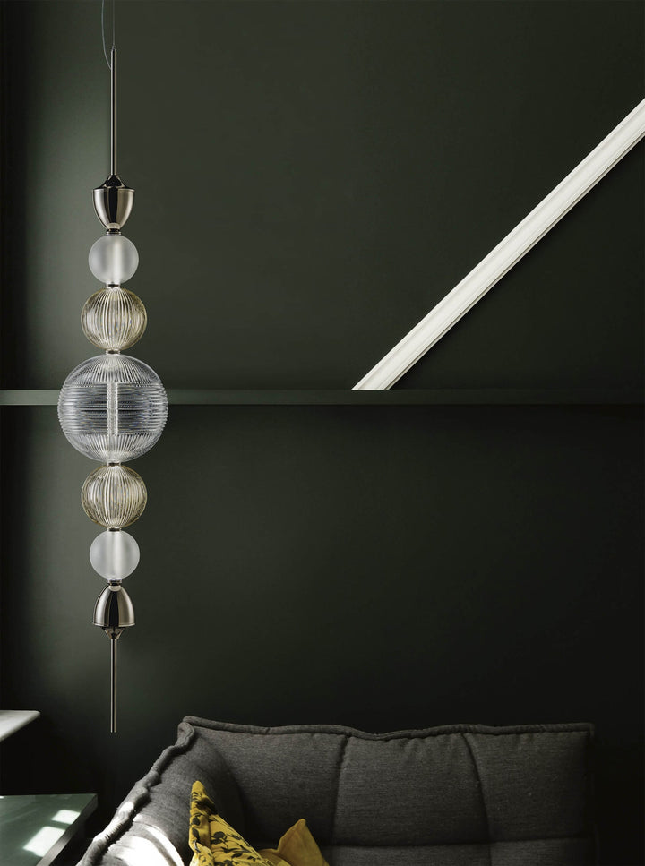 Italamp Greta Suspension Lamp with a polished nickel frame and hand-cut crystal diffuser, styled against a deep green wall – available at Spacio India.