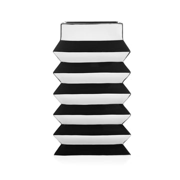 A stack of JA Vase Pleat Medium Black White boxes on a white background, inspired by Wiener Werkstätte design by Jonathan Adler.