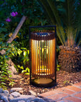 Garden solar lantern emitting a warm glow in a natural setting with plants and stones by Les Jardins available at Spacio retail stores in Mumbai & Kolkata.  