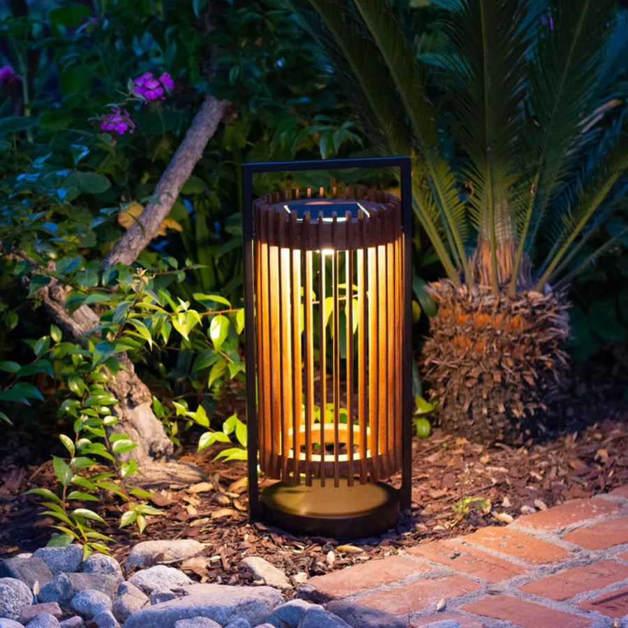 Garden solar lantern emitting a warm glow in a natural setting with plants and stones by Les Jardins available at Spacio retail stores in Mumbai & Kolkata.  