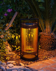 Decorative outdoor solar lantern emitting a warm glow in a garden setting by Les Jardins available at Spacio retail stores in Mumbai & Kolkata.  