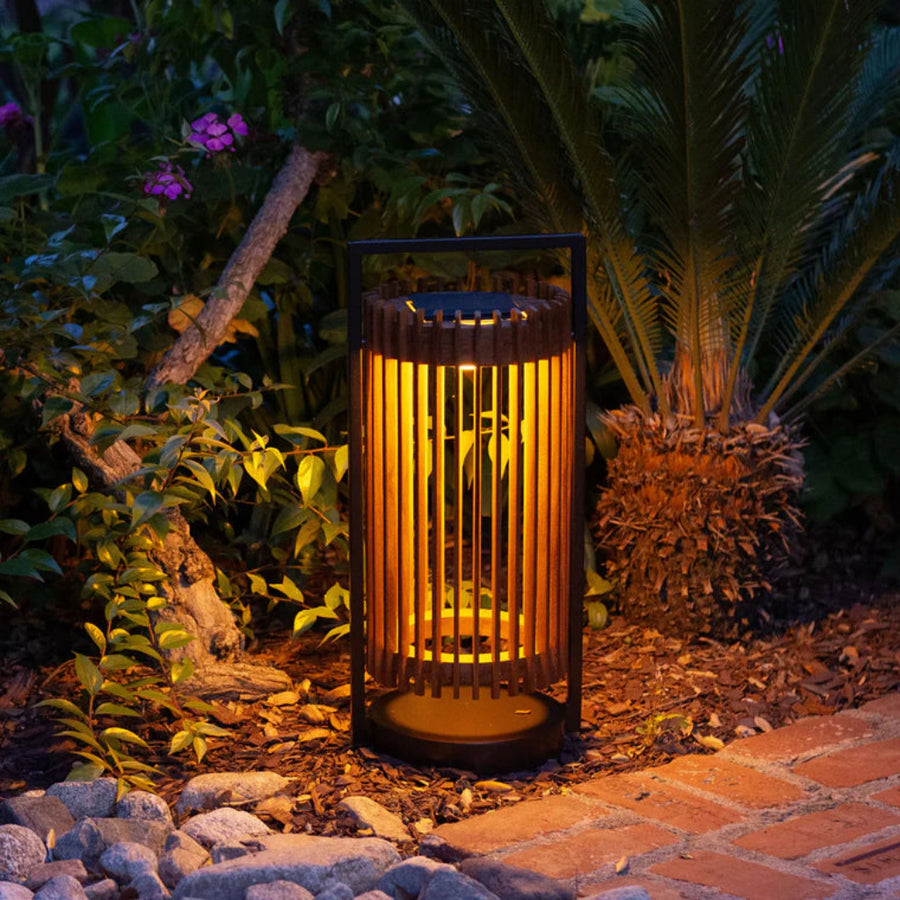 Decorative outdoor solar lantern emitting a warm glow in a garden setting by Les Jardins available at Spacio retail stores in Mumbai & Kolkata.  