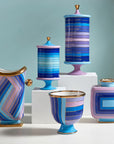 Jonathan Adler Scala Stripe Canister Vase on a pedestal with other pieces of Scala collection available at Spacio India for Luxury Home Decor Accessories collection.