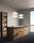 Modern kitchen with wooden island, stools, and flower-shaped pendant lights.