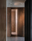 Passage through wooden doors into a dimly lit room